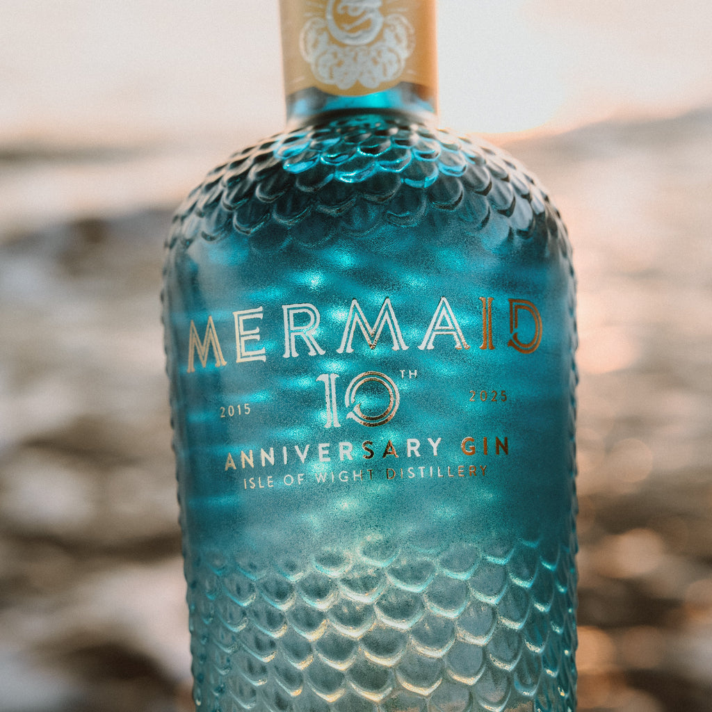 Mermaid 10th Anniversary Gin bottle on a beach